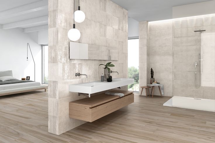 Banheiro moderno com piso laminado que imita madeira clara, revestimento em tons claros e pia dupla.