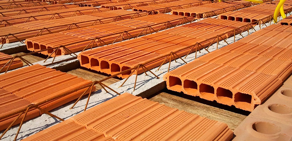 Telhas cerâmicas sobre armação de aço para laje de concreto.