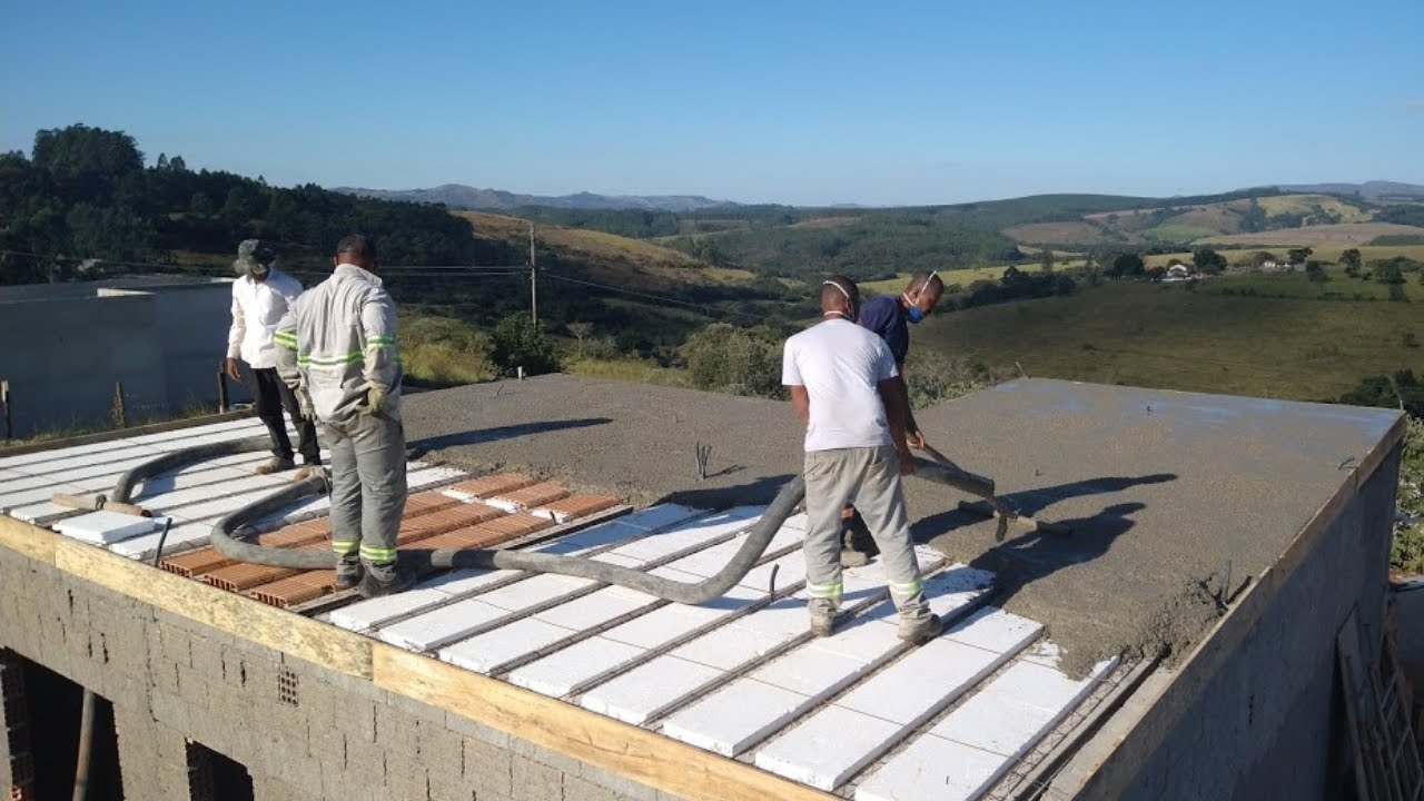 Trabalhadores concretam laje com blocos de EPS em uma casa.